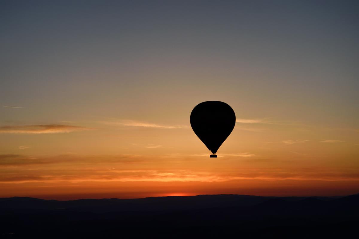 Hot air balloon silhouetted against a sunset sky